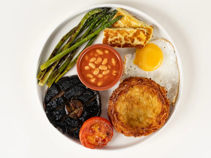 Vegetarian breakfast with asparagus, fried egg, grilled halloumi, hash nest, beans and mushroom