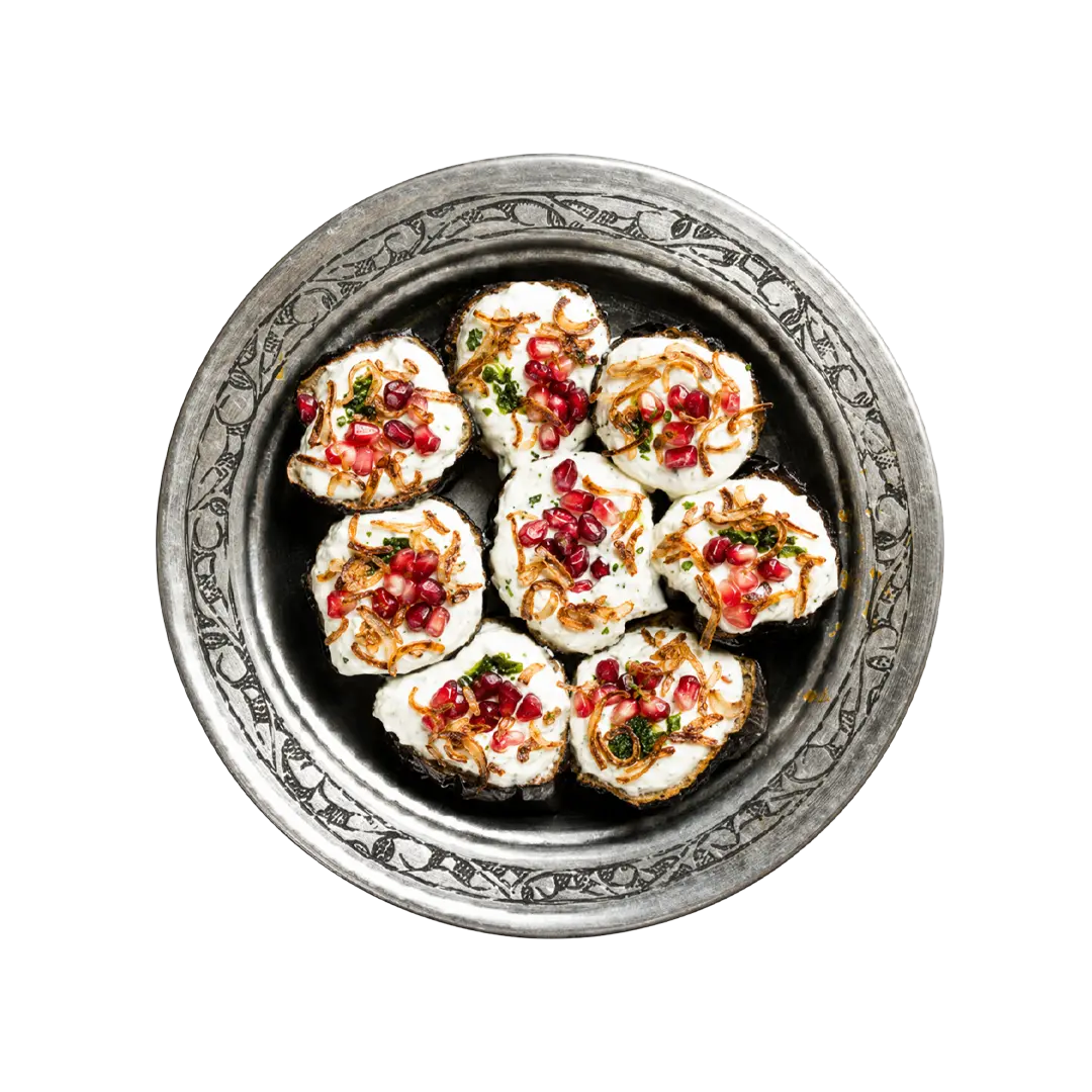 Rolled aubergine salad topped with pomegranate and herbs, vegan cold side at En Route