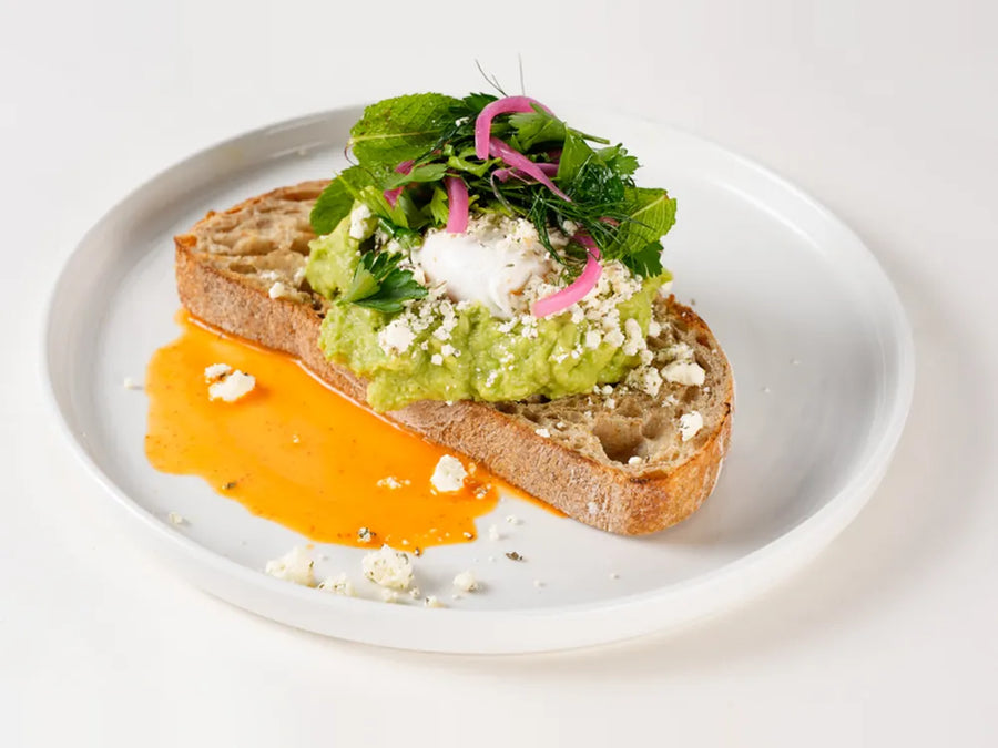 Avo Feta on sourdough toast with poached eggs, pickled onion and crumbled mint feta at Cafe Route