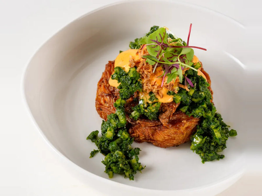 Beef Birria Benedict on a Route nest with poached egg, paprika hollandaise and cucumber dill mint salsa