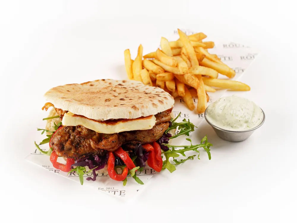 Honey harissa chicken pita with halloumi, pickled cabbage, mint yoghurt and skin on chips at Cafe Route
