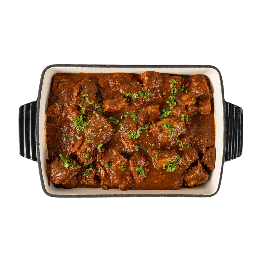 Medi birria beef in a dark serving dish, En Route lunch box main