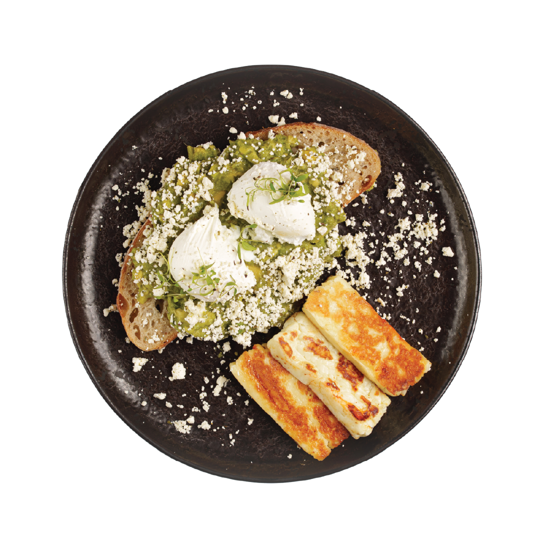 Plated dish with toast, cheese, and green spread on a black plate