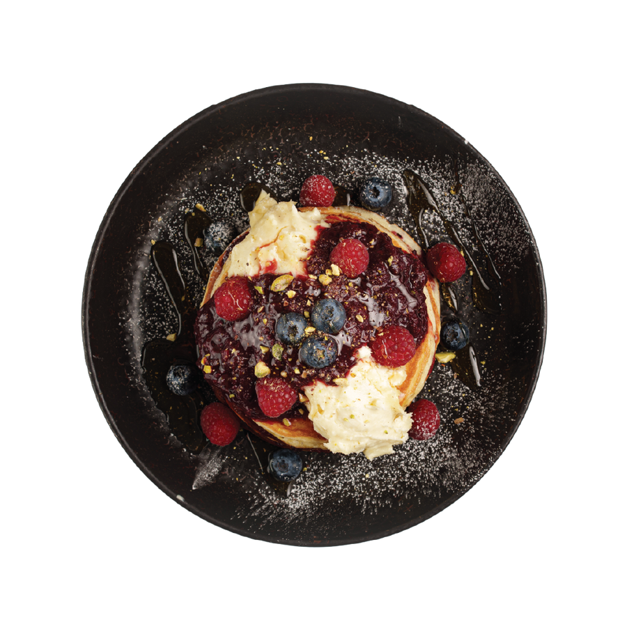 Waffles with berries on a black plate
